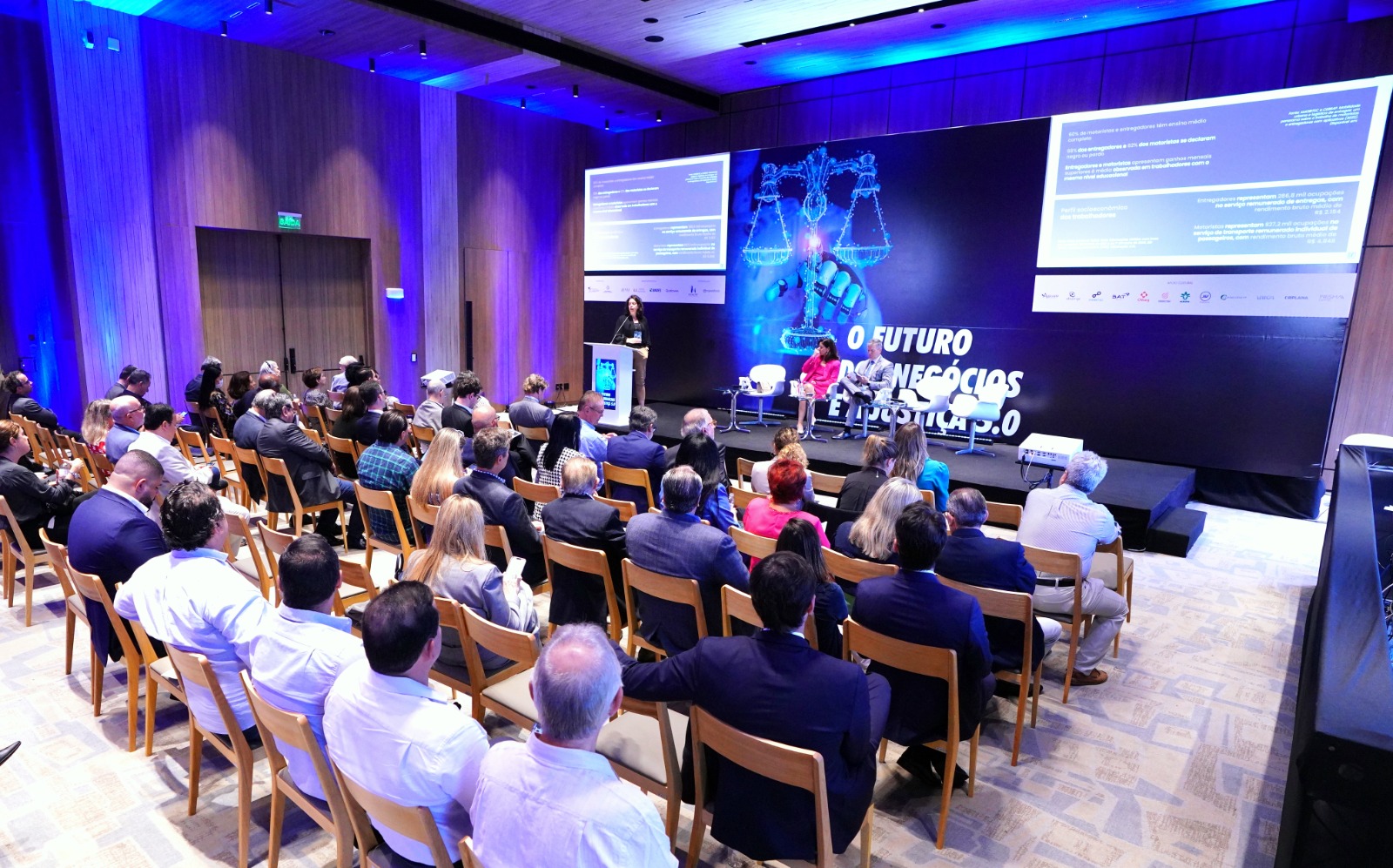 Pessoas sentadas em um auditório acompanhando debate